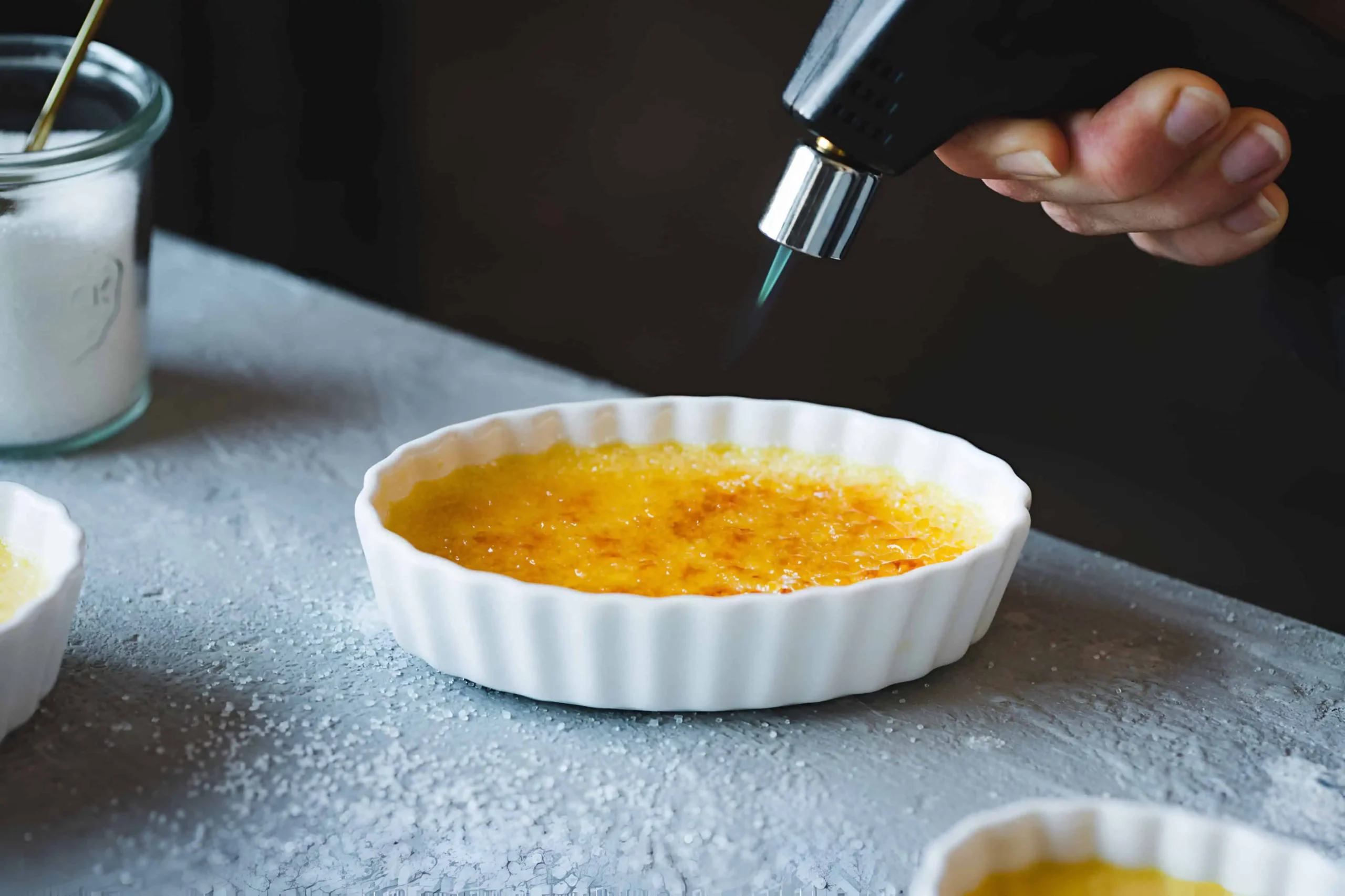 chef-preparing-creme-brulee-using-blow-torch